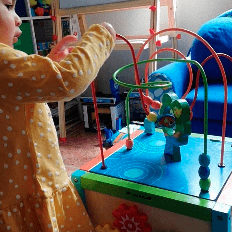 Bebé jugando con cubo de madera de actividades